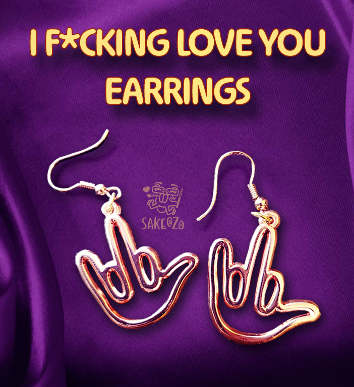 Gold earrings shaped like hands with middle fingers pointing upwards on a silky purple background with text 'I F*CKING LOVE YOU EARRINGS' and brand logo from Sakeozo.